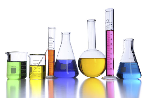 Laboratory glassware with color fluids over white background.