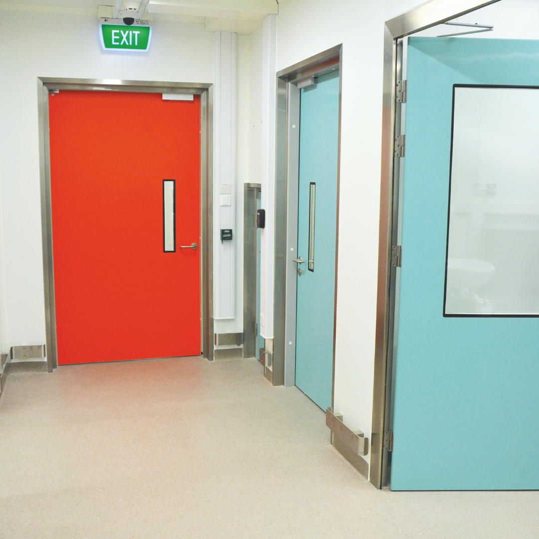 Two blue hygienic hinged FRP fire doors and 1 red hygienic hinged FRP fire door.