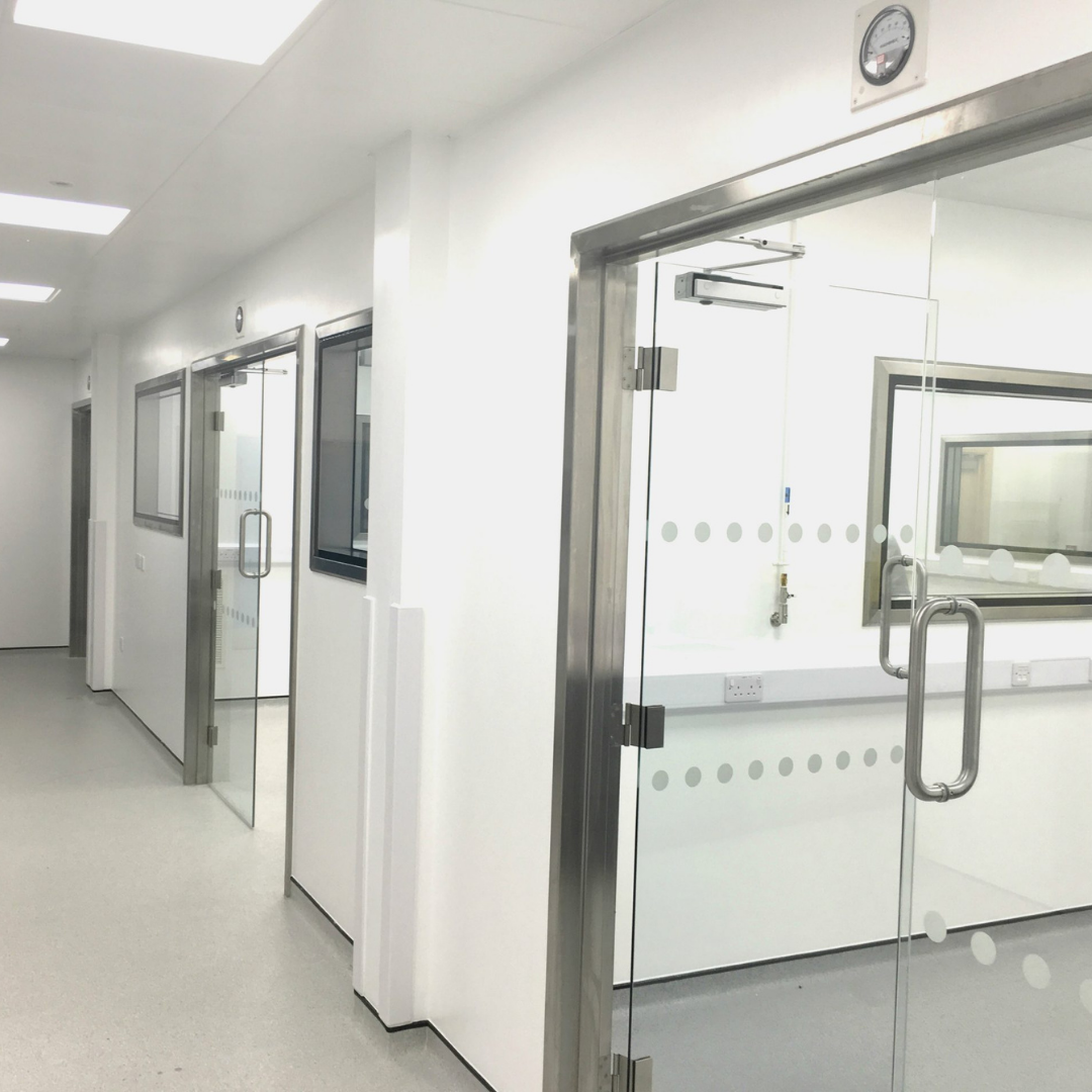 A hallway in a laboratory with glass doors.