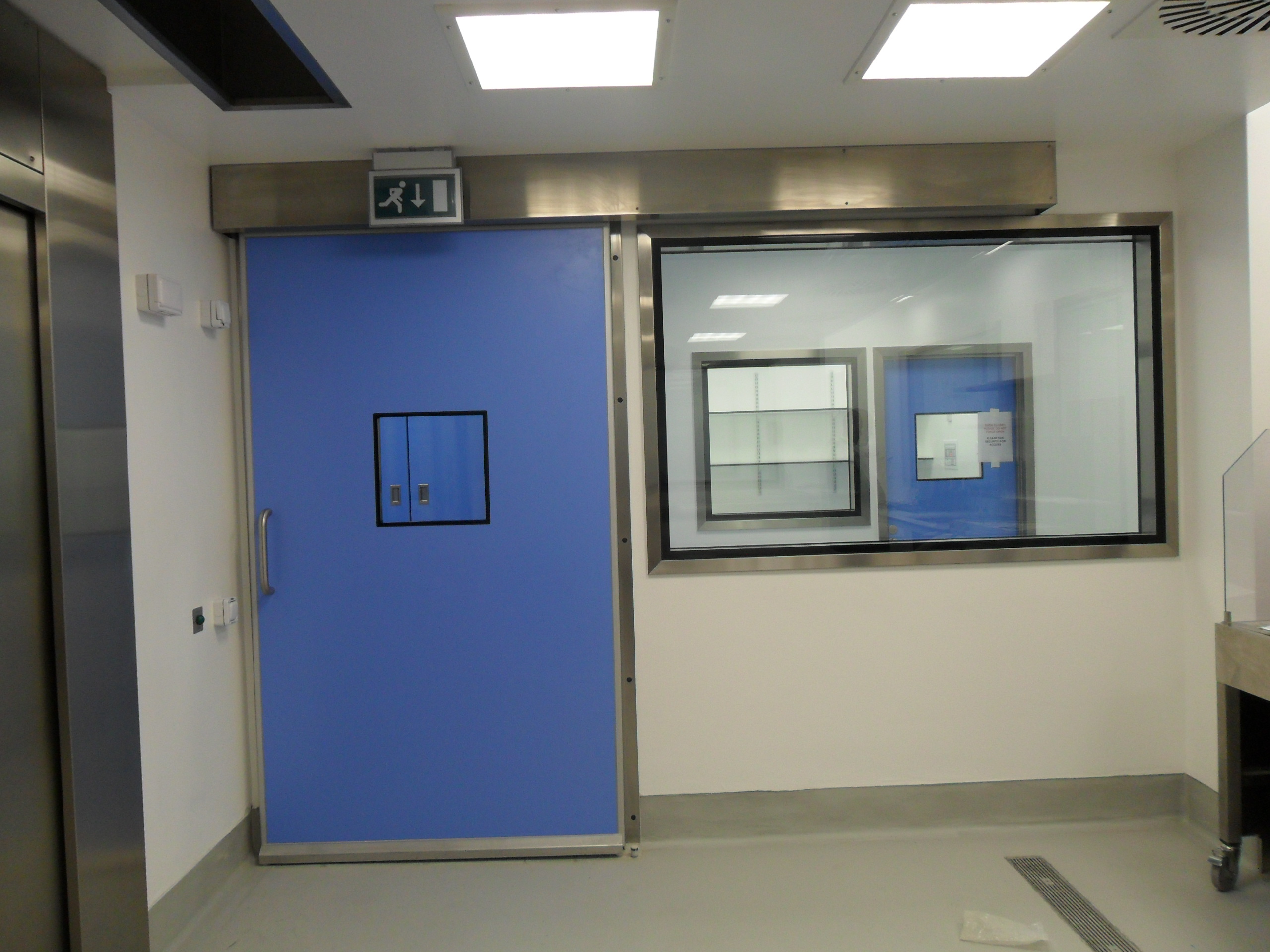 A blue hermetic door within a cleanroom.